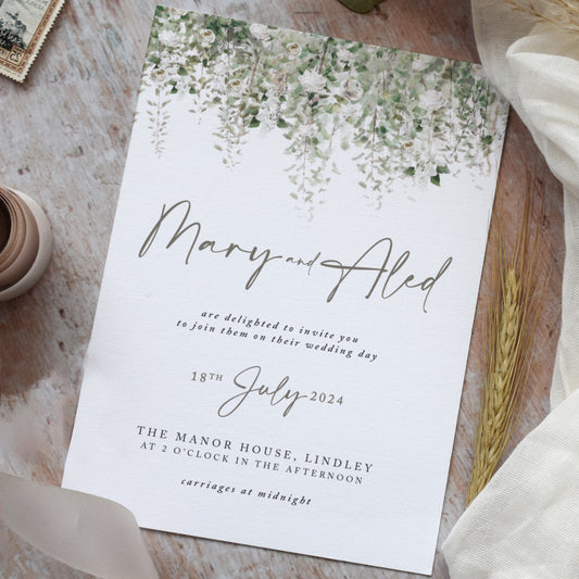 Rustic wedding invitations featuring sage green foliage