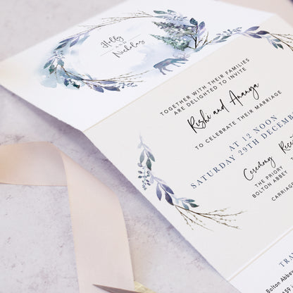 Winter wedding invites featuring pine trees and reindeer